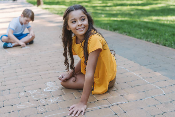 istock cute happy children drawing with chalk in park 1032586334