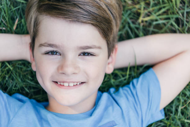 istock top view of happy child lying on grass and smiling at camera 1032586406