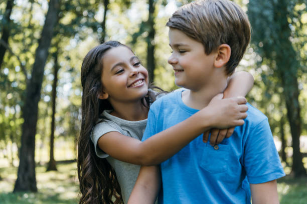 istock cute happy children hugging and smiling in park 1032586426