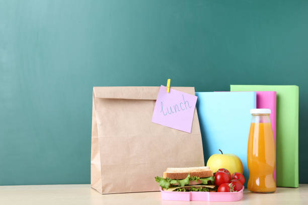 istock School lunch with paper bag and books on chalkboard background 1032594848