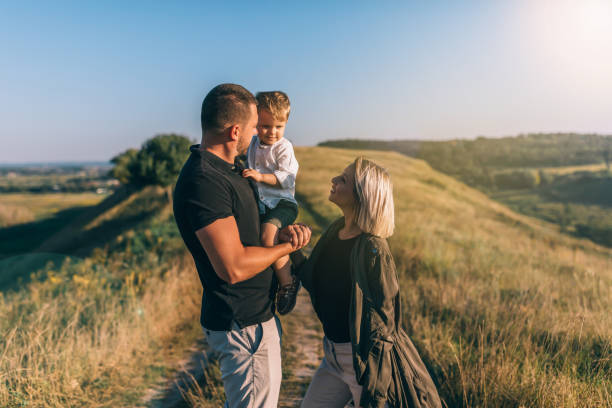 istock happy young parents looking at adorable little son while standing on rural path 1032596322