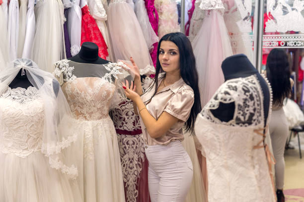 istock Beautiful bride choosing wedding dress in salon 1032600138