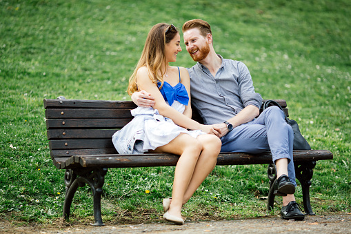 Couple in love spending time in nature on park bench