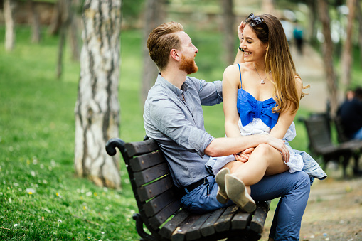 Couple in love spending time in nature on park bench