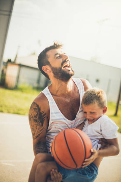 istock Happy father playing basketball with son. 1032609522