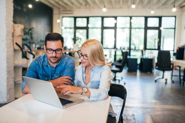 istock Two beautiful young designers working together in modern co-working office. 1032612974