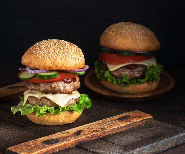 istock large burger with two fried cutlets, cheese and vegetables 1032613088