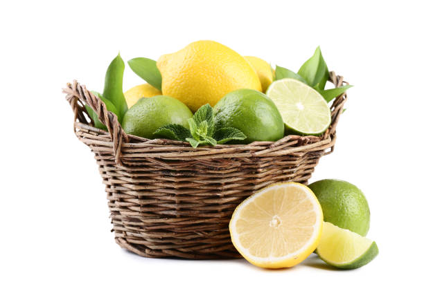 Lemons and limes with mint leafs in basket on white background