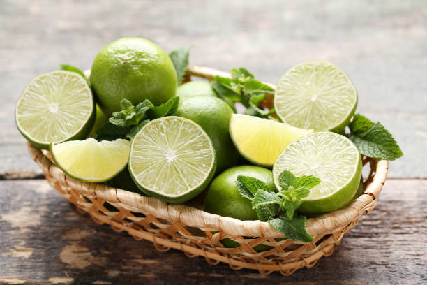 istock Ripe limes in basket on grey wooden table 1032617064