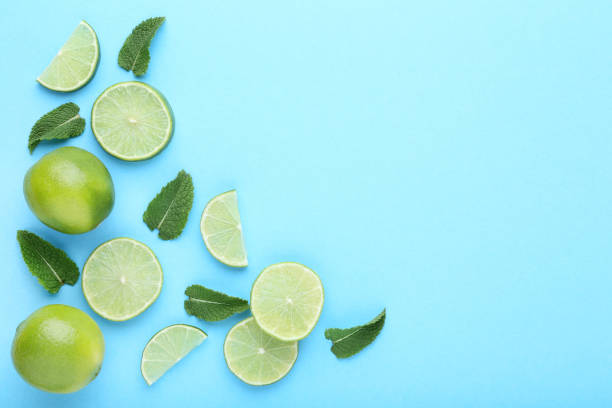 istock Ripe limes with green leafs on blue background 1032617290
