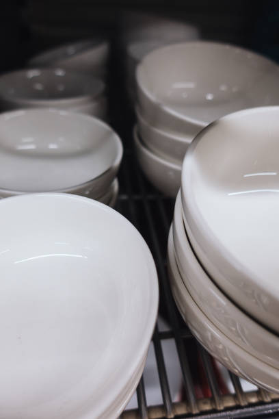 istock Bulk of white ceramic bowls on the rack. 1032629178