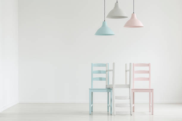 istock Lamps above pastel chairs in white empty living room interior with copy space on the wall. Real photo 1032629426