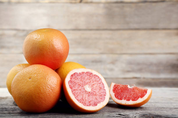 istock Ripe grapefruits on grey wooden table 1032629476