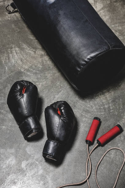 istock punching bag with jumping rope and boxing gloves on concrete surface 1032632676