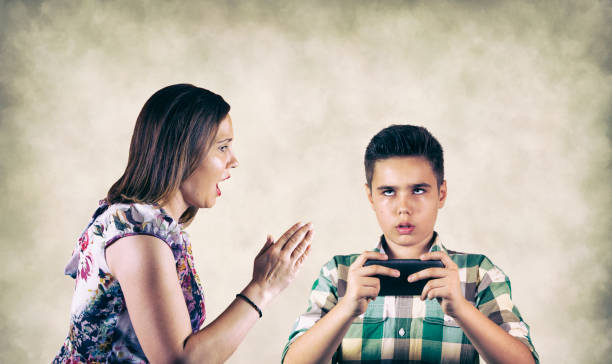 mother shouting on son who plays mobile game - homework teenager mobile phone school imagens e fotografias de stock