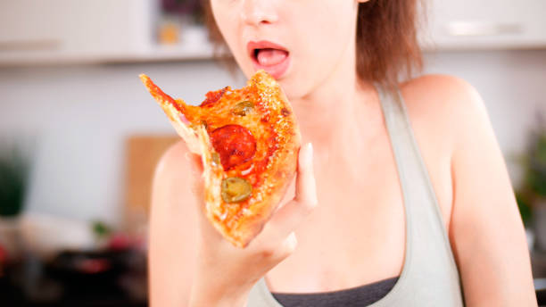 istock Woman eating junk fast food 1032637530
