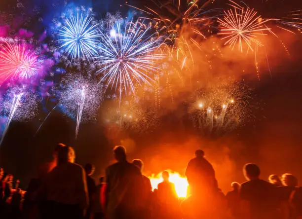 Photo of People standing in front of colorful Firework