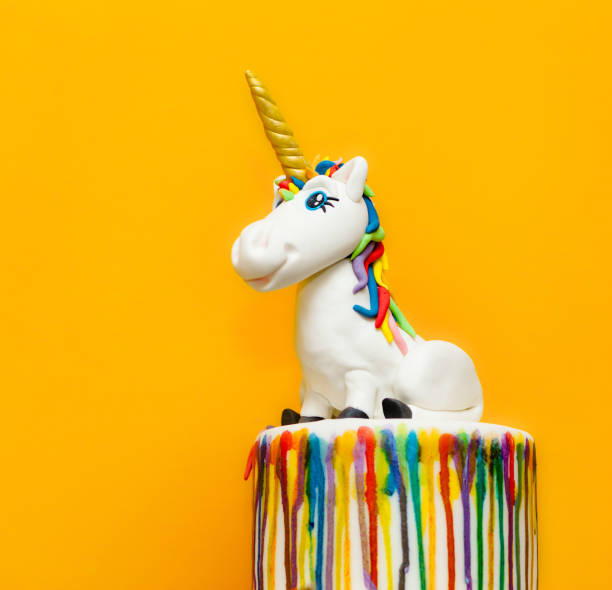 istock Unicorn On Colorful Cake Against Yellow Background 1032650272