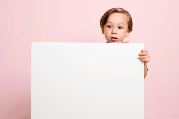 istock Cute child is holding white poster. 1032651386