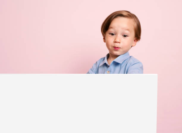 istock Cute child is holding white poster. 1032651402
