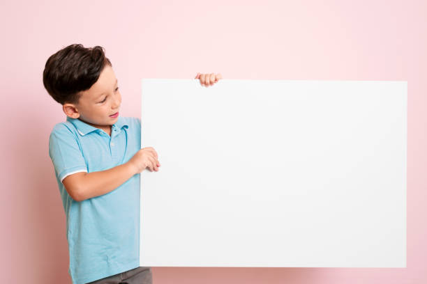 istock Cute child is holding white poster. 1032651528