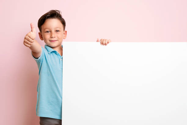 istock Cute child is holding white poster. 1032651548