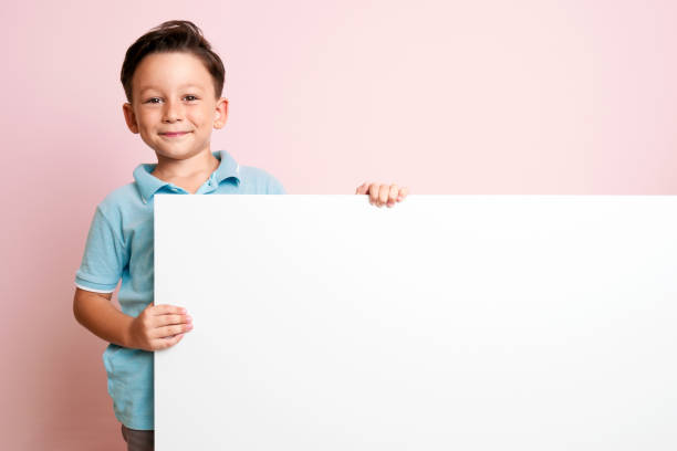 istock Cute child is holding white poster. 1032653966