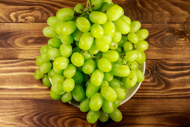 istock Tasty fresh white grape in a plate on wooden table 1032654744