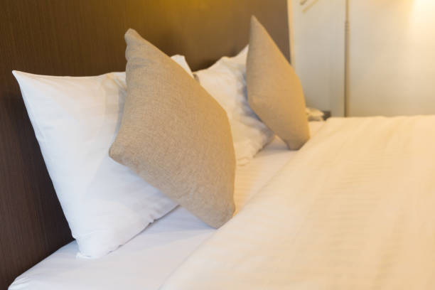 istock White bedding and two pillow in hotel room 1032655120