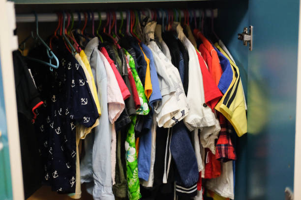 armário de vestir com roupas dispostas em cabides. guarda-roupa colorido para as crianças. - child clothing arrangement hanger - fotografias e filmes do acervo