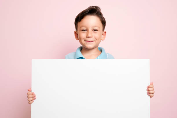 istock Cute child is holding white poster. 1032655230