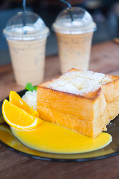 istock Honey toast served with orange slice and orange sauce on black dish 1032655324