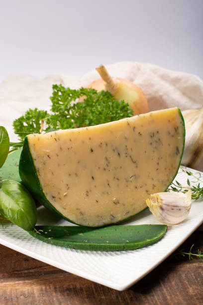 fromage à pâte dure spécialité néerlandaise fait de lait de vaches avec différentes épices et herbes vertes fraîches - basiron photos et images de collection