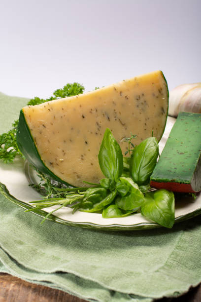 fromage à pâte dure spécialité néerlandaise fait de lait de vaches avec différentes épices et herbes vertes fraîches - basiron photos et images de collection