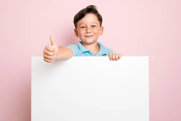 istock Cute child is holding white poster. 1032655866