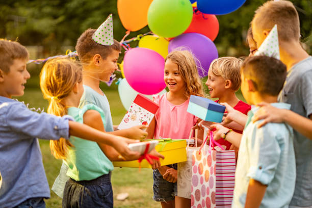 Children came to birthday party with presents Group of children at birthday partu in public park birthday present stock pictures, royalty-free photos & images