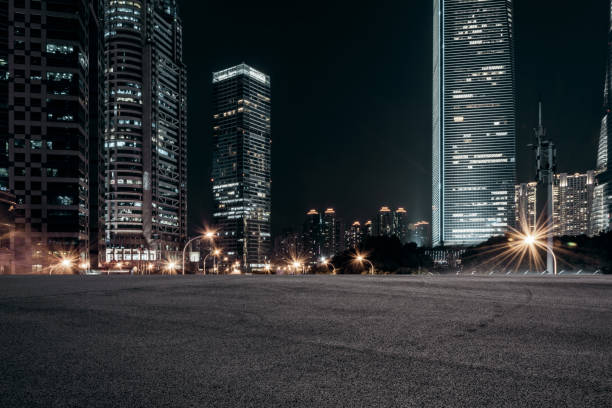 empty pavement and modern buildings in city in night