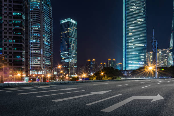 istock empty pavement and modern buildings in city in night 1032659700