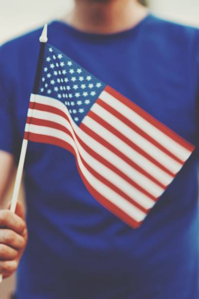 istock Midsection Of Person Holding American Flag 1032677898