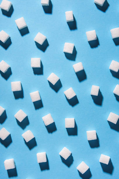 white sugar cubes isolated on blue background. Top view stock photo