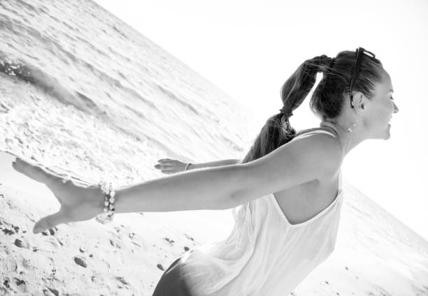istock happy modern woman on seacoast in evening rejoicing 1032680330