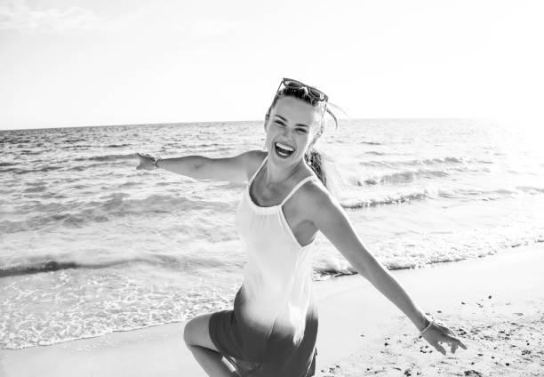 istock happy modern woman on seashore in evening having fun time 1032681562