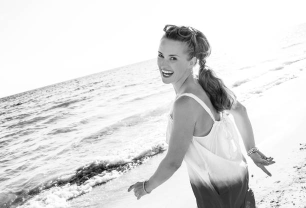istock smiling young woman on beach in evening walking 1032681570