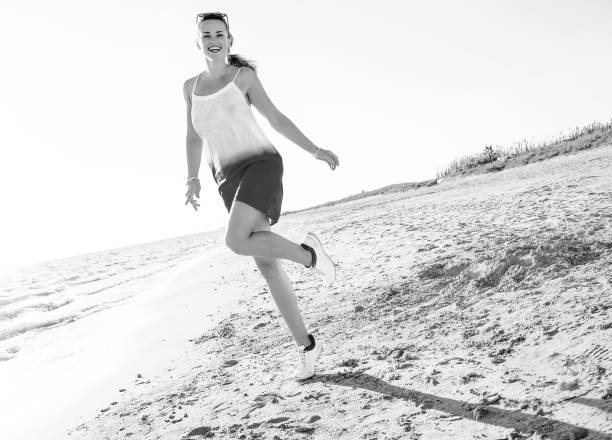 istock smiling young woman on beach in evening having fun time 1032681698