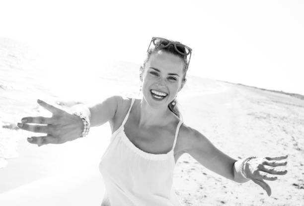 istock smiling young woman on beach in evening having fun time 1032681880
