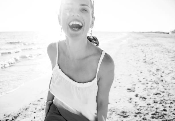 wonderfully cheerful mood. Portrait of smiling young woman in dress on the beach in the evening having fun time