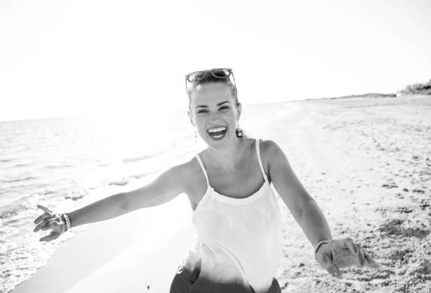 istock smiling modern woman on beach in evening having fun time 1032681952