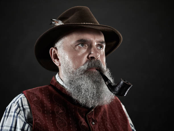istock dramatic portrait of senior smoking tobacco pipe 1032683348