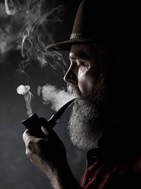 istock dramatic portrait of senior smoking tobacco pipe 1032683392