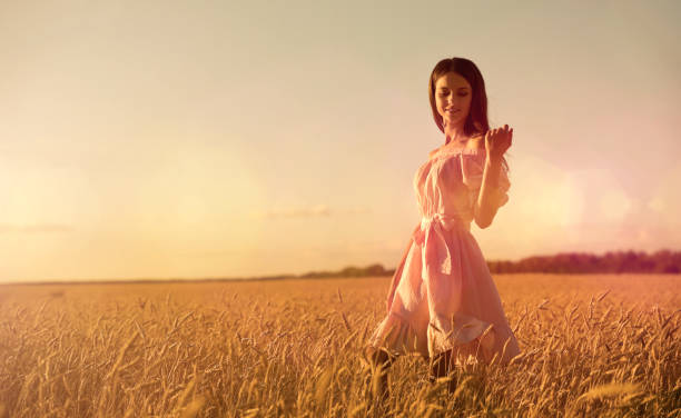 istock Woman in wheat field at sunset 1032686674